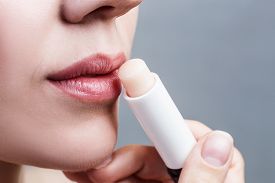 Chapped lips - Picture of lady applying lip balm.